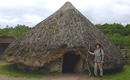 Henry beside reconstructed Neolithic Hut